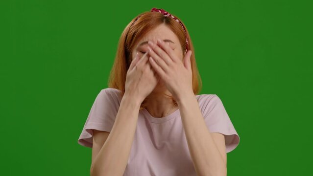 Sick woman portrait sneezing against green screen bacground. female in need of doctor appointment for checkup. Healhcare concept.