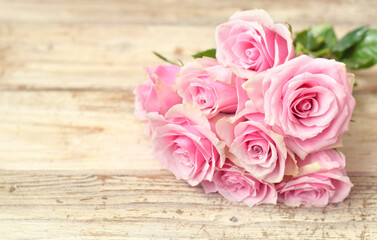 Pink roses on vintage old wooden table closed up flower buds and petals