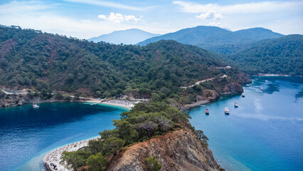 Aerial view of blue sea, rocky coast, trees and beach. Fethiye, Oludeniz, Turkey. Tropical landscape. Tourism background.