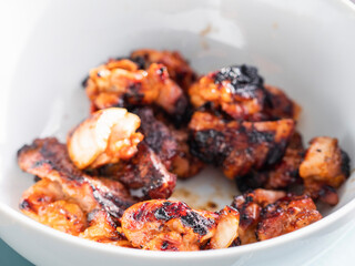 Properly cooked small chicken portions in a white bowl. Sumer picnic food concept. Barbeque season time. Food to share.