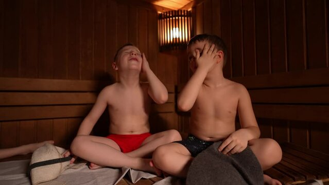 Children sit and warm themselves in a hot sauna