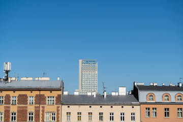 Fototapeta premium Krakow urban architecture. Aerial view of Cracow tenement houses and Unity Centre Tower, office skyscraper building in Kraków, Poland.