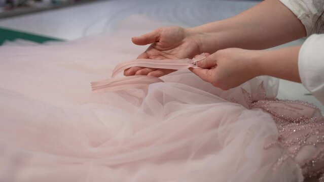 A seamstress sews a festive dress