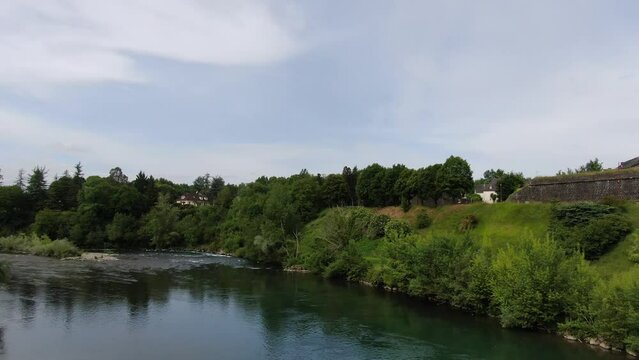 Birds flying all around with the beauty of an ancient city built next to a stream