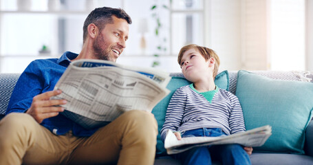 Father, child and reading newspaper on sofa relaxing together in the living room at home. Happy dad and kid enjoying the news in relax on lounge couch for knowledge on weekend or holiday at the house - Powered by Adobe