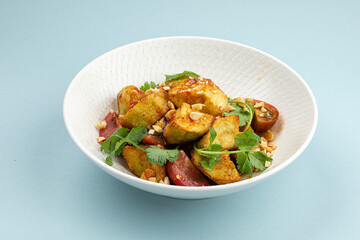 Portion of gourmet crispy fried eggplant salad on blue background