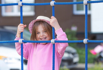 A little girl walks in the spring on the playground. The child is having fun playing outdoors on a...