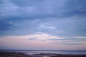 Obraz premium sunset over the sea. Beautiful cloudy evening sky. Dam bridge in the distance