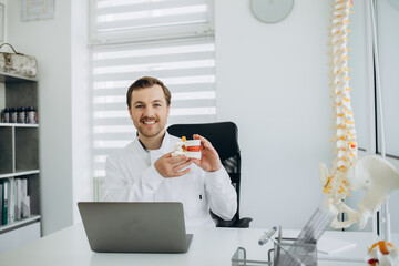 a vertebrologist doctor works on a camera behind a laptop