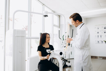 Obraz premium Female patient examining spine at physiotherapist at vertebrology center