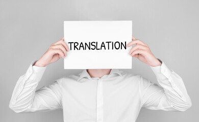 Man covers his face with white paper with text translation