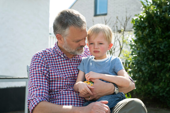 Man sitting in chair with his son