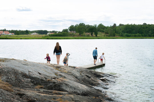 Family walking on rocks and jetty by sea