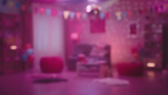 Blurred colorful glow reflecting from a mirrored disco ball inside the room. Defocused interior of a room decorated for a home party or birthday. The concept of entertainment and disco style parties.
