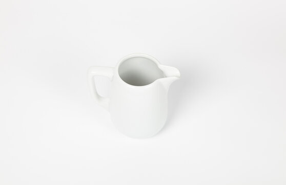 Milk jug on white background. Porcelain sauce boat, pitcher, creamer or ceramic gravy boat. Space for text, for advertising, banner, signboard, menu and printed materials