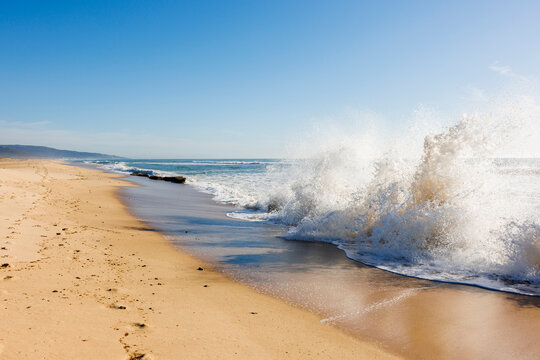 Waves on beach under clear sky