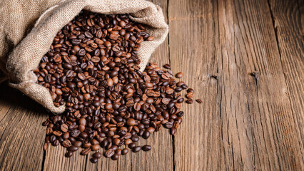 Palone ziarna kawy w jutowym worku na starych deskach