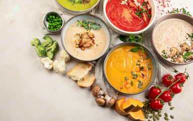 Composition with various soups, ingredients and space for text on white background. Healthy food.