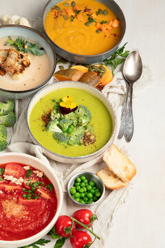 Composition with various soups, ingredients and space for text on white background. Healthy food.