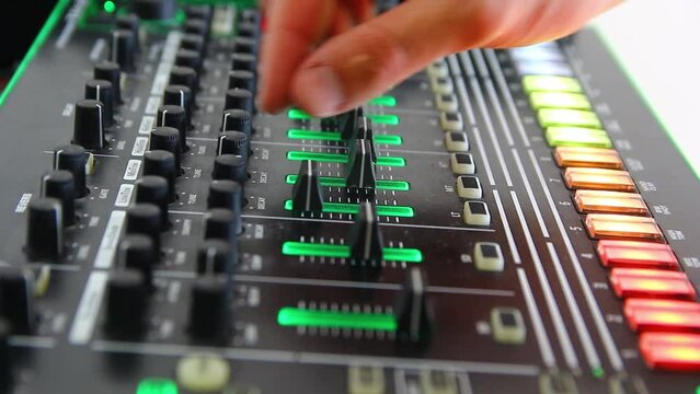 DJ's hand moves audio tracks on the DJ console