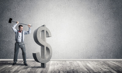 Determined banker man in empty concrete room breaking dollar figure