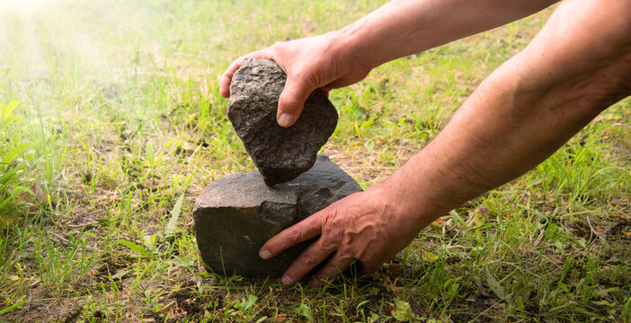 Hands of primitive man with stone