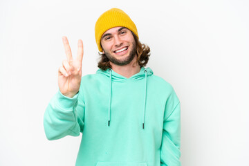 Young handsome man isolated on white chroma background smiling and showing victory sign
