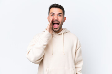 Young caucasian man isolated on white background shouting with mouth wide open