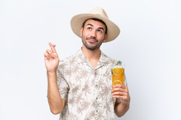 Young caucasian man holding a cocktail isolated on white background with fingers crossing and wishing the best