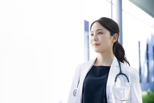 採用や転職で使えそうな逆光が美しいアジア系の見上げる女医さんの横顔イメージ　アップ　