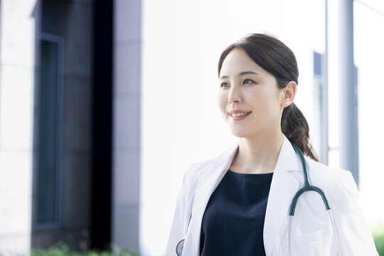 Image of a profile of a female doctor looking up at an Asian woman with beautiful backlighting that could be used in a hiring or career change. close-up　