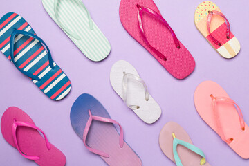 Many bright flip flops on color background, top view