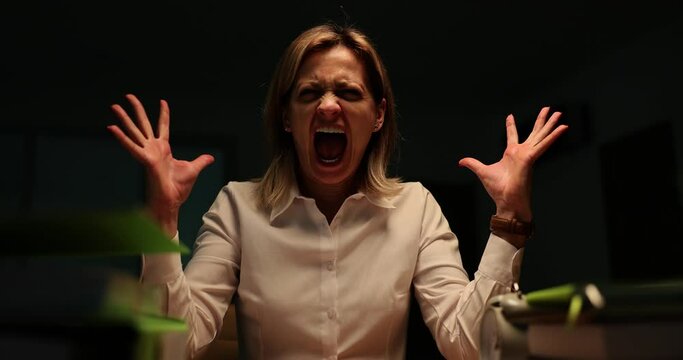 Portrait of a manager woman screaming in the evening in office and going crazy at work. Overtime and burnout at work