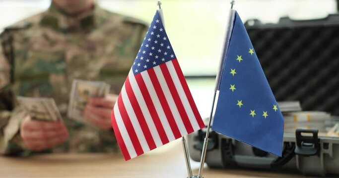 Military counts dollars money with eu and usa flags closeup. Sale of military weapons and war in Ukraine