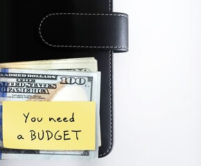 Yellow note on black notebook with handwriitten text YOU NEED A BUDGET! concept of money goal setting and remind oneself to take action without excuses for financial planning