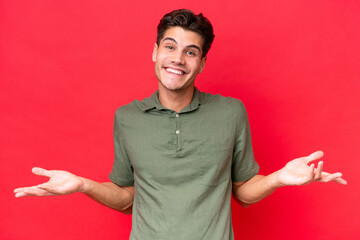 Young caucasian handsome man isolated on red background happy and smiling