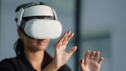Young woman in virtual reality glasses and raised hand touches the air. Simulation and metaverse concept