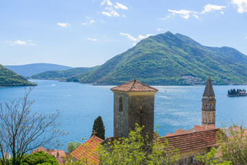 The bell tower of St Nicholas church in Perast and Verige is the strait of Boka Kotorska in the background. Montenegro - 603963105