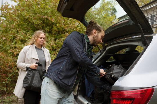 Couple packing bags into car boot