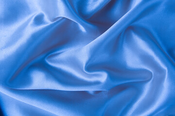 Abstract blue silk fabric texture background. Creases of satin	
