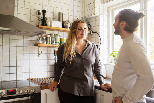 Couple standing by kitchen window