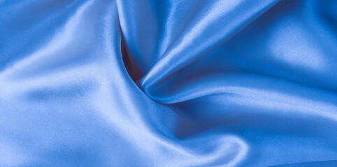Abstract blue silk fabric texture background. Creases of satin	
