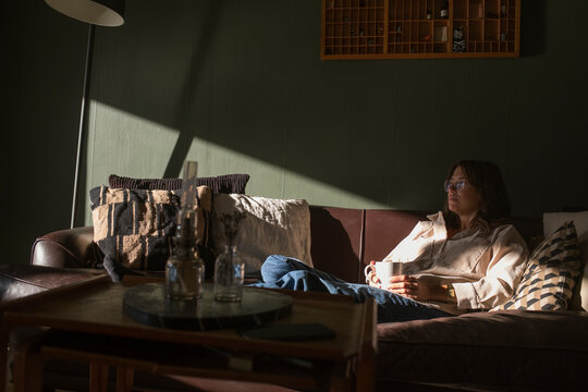 Woman sitting on sofa with coffee cup