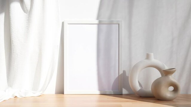 Video white photo frame mockup with beige and white vases on wooden table 