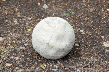 Old and broken soccer ball standing on the ground