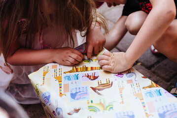 The children unpack the gift. Close up of hands opening a gift box.