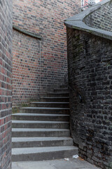 A mysterious and hidden old back alley with staircase in London at night © gdefilip