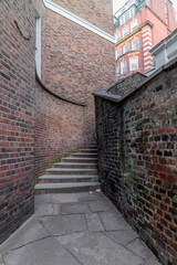 A mysterious and hidden old back alley with staircase in London at night © gdefilip