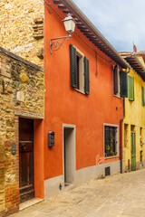 Fototapeta na wymiar The colorful medieval houses and alleys of San Quirico d'Orcia in a sunny spring day