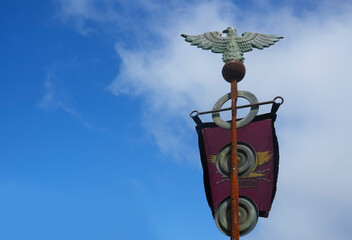 Old Roman standard or waving red Flag with Aquila and SPQR on blue sky background. Gonio-Apsaros...